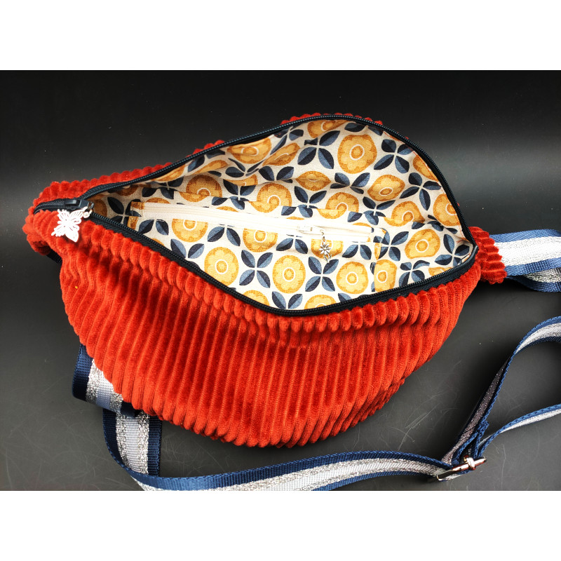 Sac banane velours côtelé marron brique int Sac banane velours côtelé marron brique taille médium. Intérieur en coton motif avec une poche zippée. Bandoulière en sangle lurex.