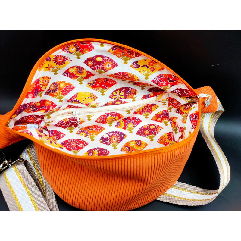 Sac banane en velours côtelé orange, sangle lurex, intérieur en coton coloré motif éventail avec une poche zippée. Intérieur