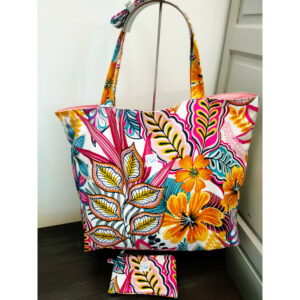 Sac de plage motif feuilles colorées en tissu enduit imperméable, réversible. Il comprend une poche zippée et un mousqueton accroche-clé